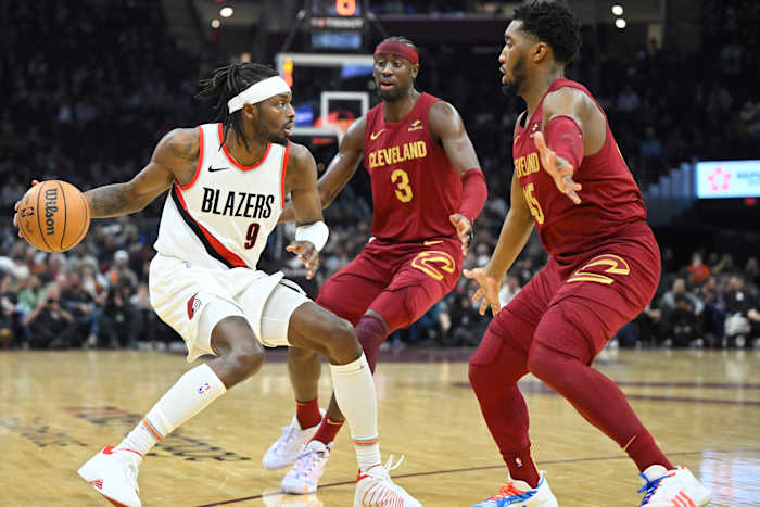 Nov 30, 2023; Cleveland, Ohio, USA; Cleveland Cavaliers guard Caris LeVert (3) and guard Donovan Mitchell (45) defend Portland Trail Blazers forward Jerami Grant (9) in the second quarter at Rocket Mortgage FieldHouse.